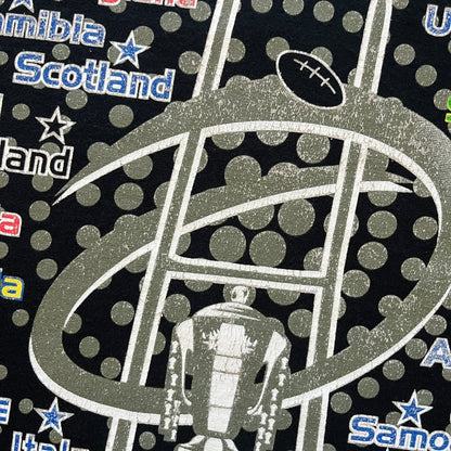2015 Rugby World Cup tee featuring a front print with a world map, all participating countries, and “2015 World Cup” text. The back displays the date and location of the grand final along with the text “20 teams – only 1 winner.” An official commemorative piece from the 2015 tournament.