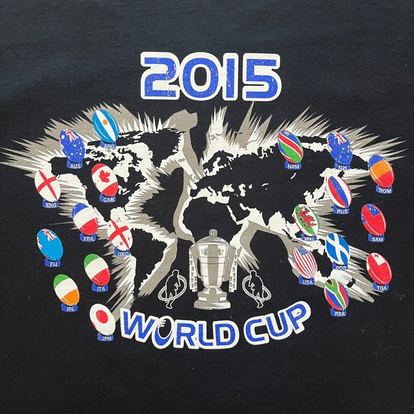 2015 Rugby World Cup tee featuring a front print with a world map, all participating countries, and “2015 World Cup” text. The back displays the date and location of the grand final along with the text “20 teams – only 1 winner.” An official commemorative piece from the 2015 tournament.