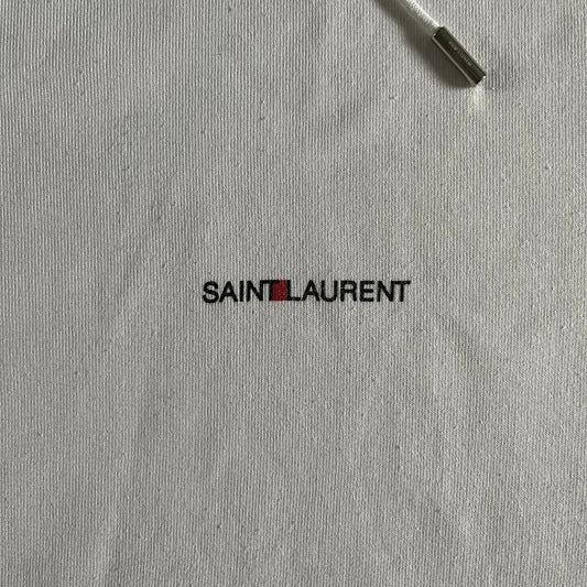 Saint Laurent Small Logo White Hoodie made in France from 100% cotton. Features a minimalist chest logo with “Saint” and “Laurent” separated by a small red square, silver-tipped drawstrings engraved with branding, and a classic front pocket. Designed with the brand’s signature minimalist aesthetic.