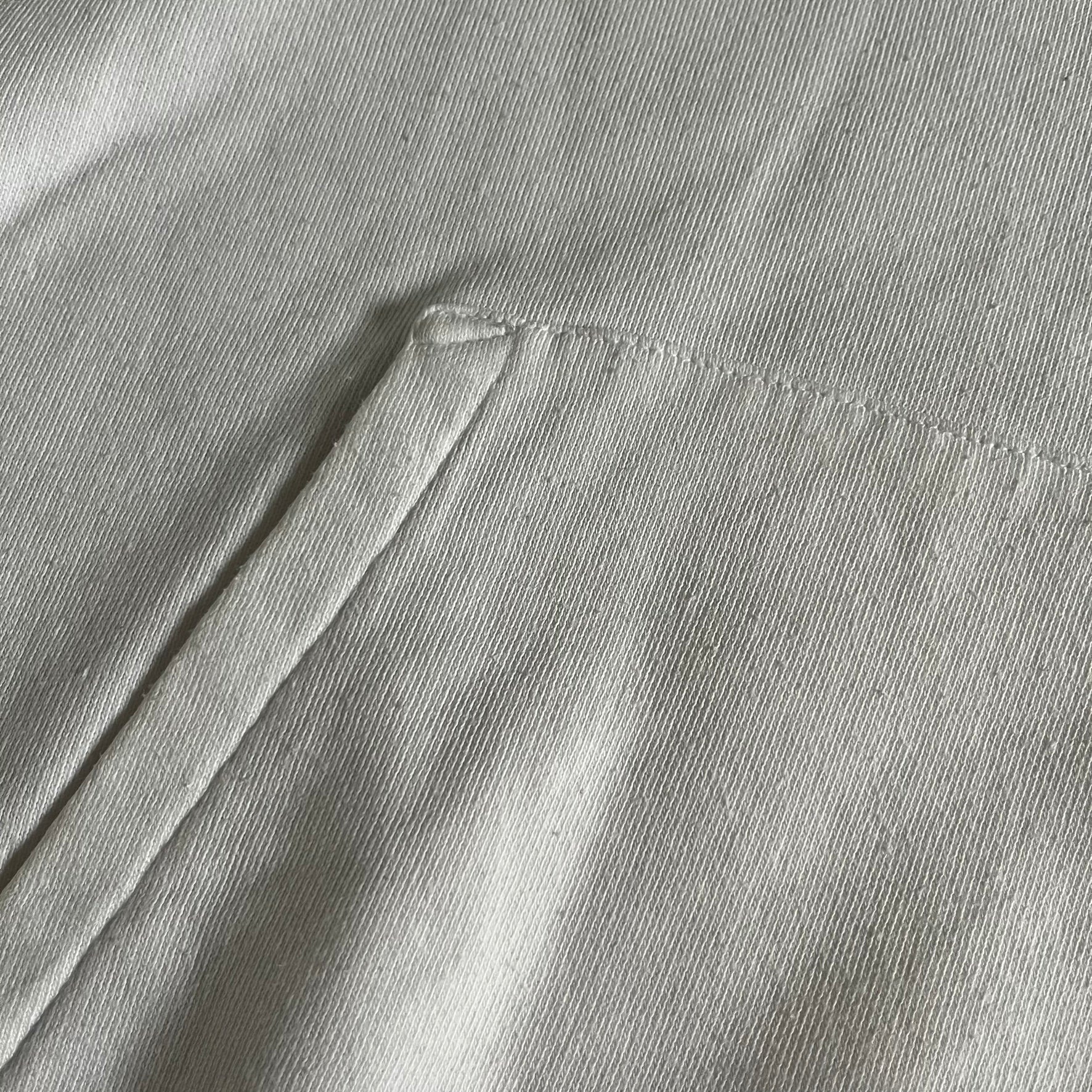 Saint Laurent Small Logo White Hoodie made in France from 100% cotton. Features a minimalist chest logo with “Saint” and “Laurent” separated by a small red square, silver-tipped drawstrings engraved with branding, and a classic front pocket. Designed with the brand’s signature minimalist aesthetic.