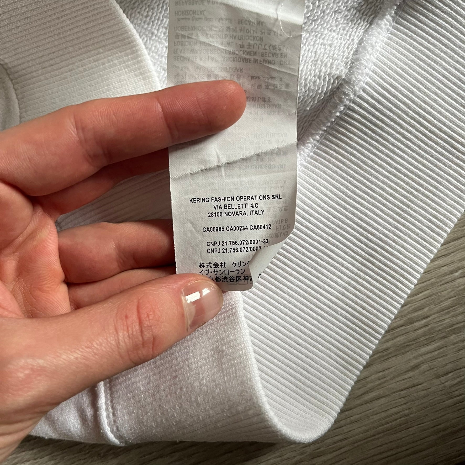 Saint Laurent Small Logo White Hoodie made in France from 100% cotton. Features a minimalist chest logo with “Saint” and “Laurent” separated by a small red square, silver-tipped drawstrings engraved with branding, and a classic front pocket. Designed with the brand’s signature minimalist aesthetic.