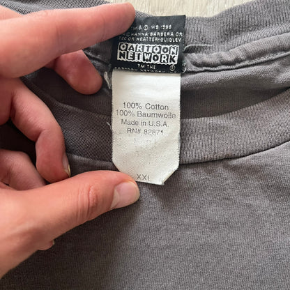 Gray Scooby-Doo tee from 1998, officially licensed by Warner Bros. Studio Store. Graphic shows Scooby emerging through the shirt as if he tore it, paired with classic text. Single-stitch USA-made construction adds authentic vintage charm.