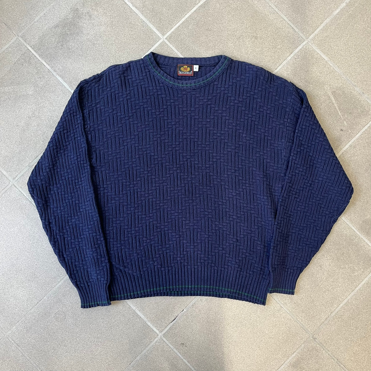 Sedgefield 1990's Basketweave Navy Sweater is a heavyweight navy sweater made in the USA, featuring a thin green line detail on the collar.