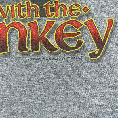 Shrek 2003 “I’m with the Donkey” Gray Tee is a gray T-shirt made from 90% cotton and 10% polyester. The front features Shrek pointing to the side with “I’m with the Donkey” text in a medieval font, and a small DreamWorks Shrek 2003 licensing print below. The neck tag shows Shrek and Universal Studios branding.