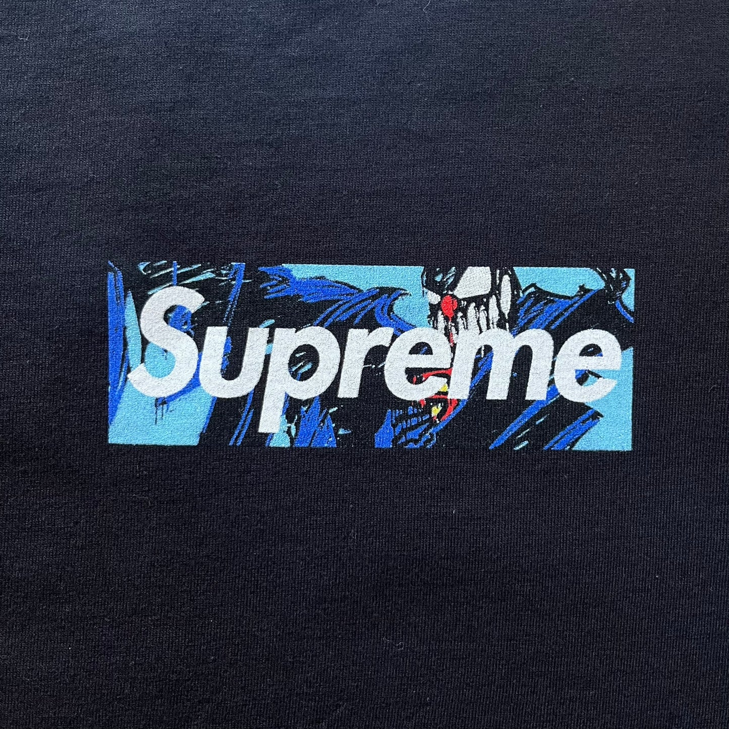 Black Batpreme tee designed by Slawn with Supreme Box Logo and his iconic Batman graphic on the front. Printed neck tag with signature and back shows handwritten-style text saying “This really isn’t real Supreme” with Slawn signature and the Supreme bogo. A rare, art-driven streetwear essential.
