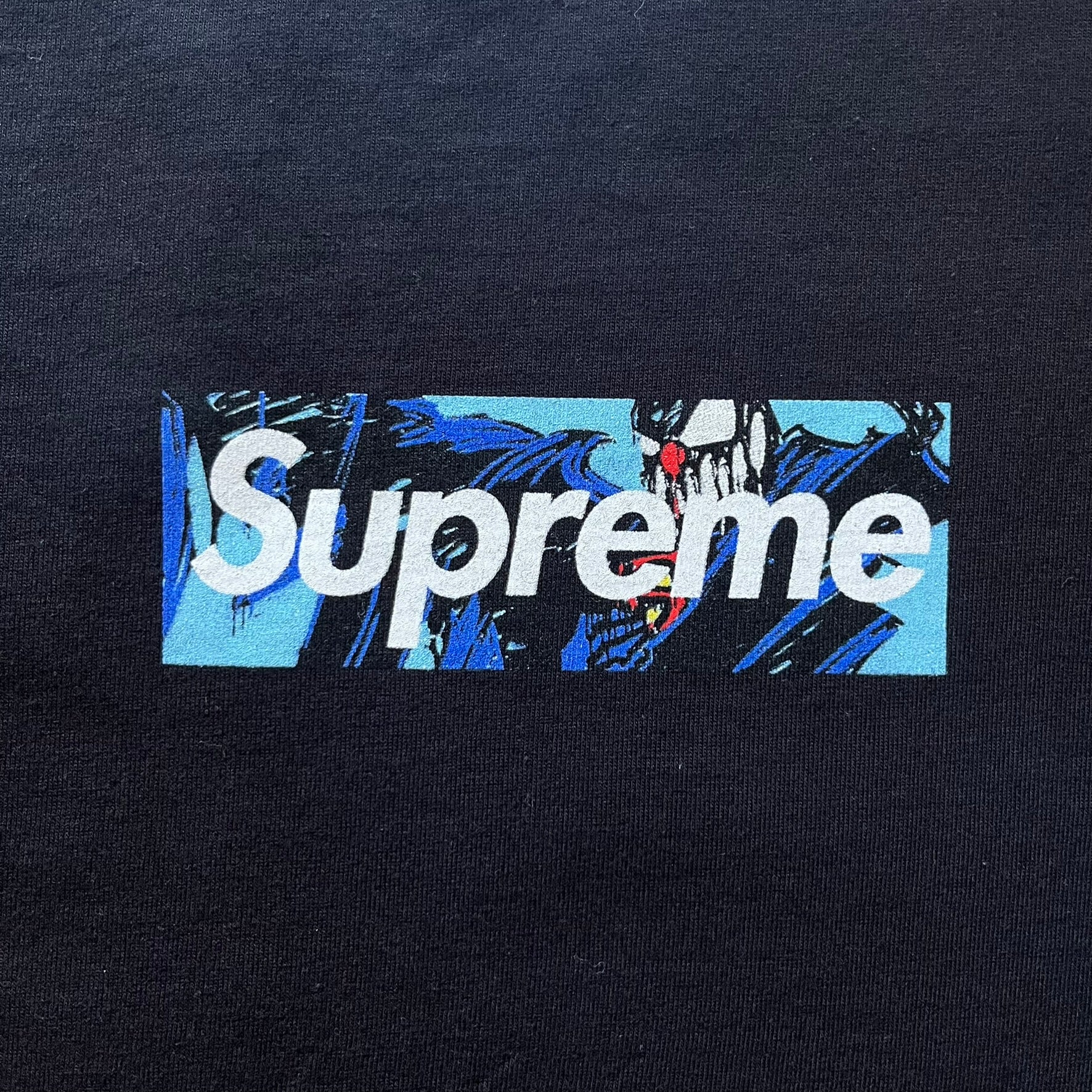 Black Batpreme tee designed by Slawn with Supreme Box Logo and his iconic Batman graphic on the front. Printed neck tag with signature and back shows handwritten-style text saying “This really isn’t real Supreme” with Slawn signature and the Supreme bogo. A rare, art-driven streetwear essential.