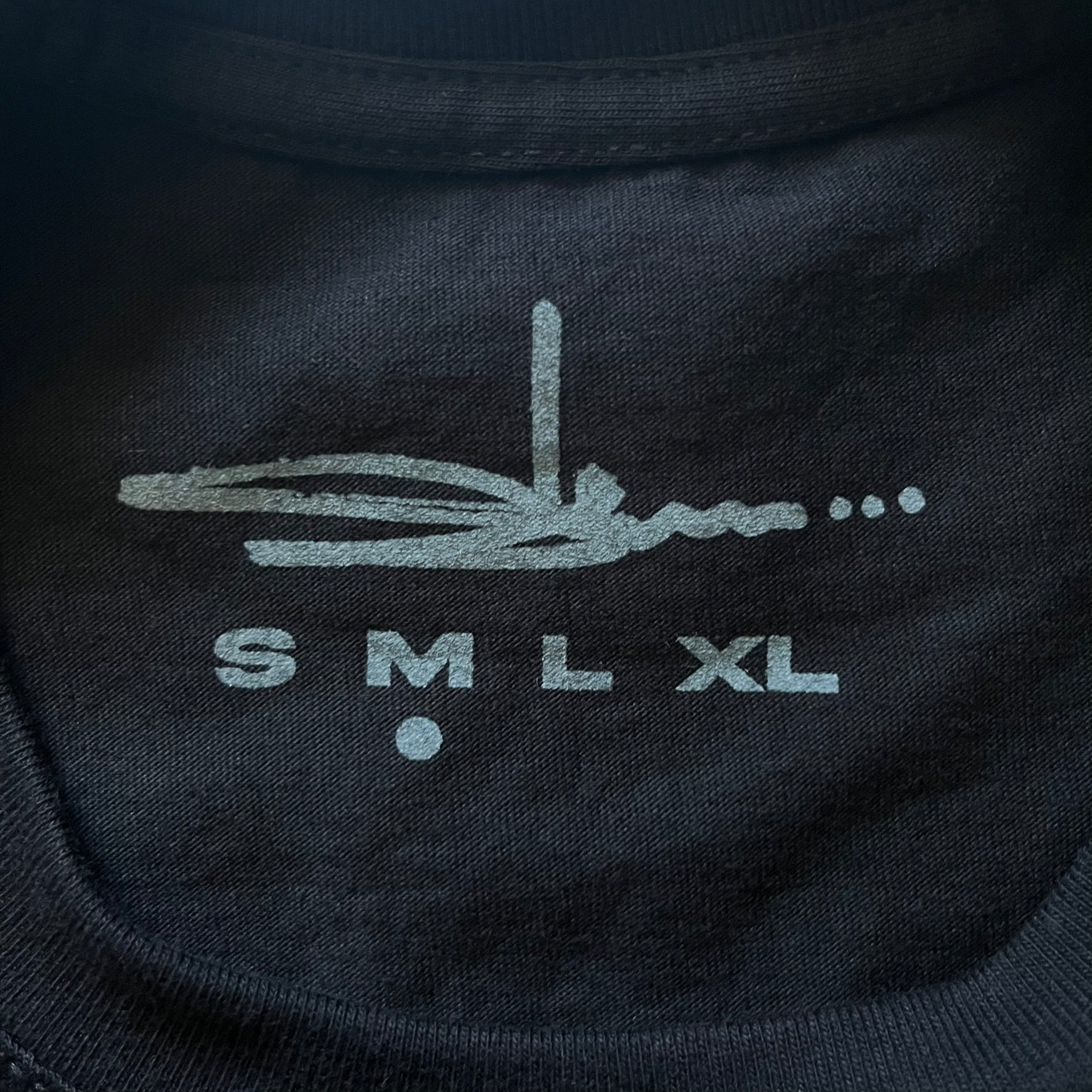 Black Batpreme tee designed by Slawn with Supreme Box Logo and his iconic Batman graphic on the front. Printed neck tag with signature and back shows handwritten-style text saying “This really isn’t real Supreme” with Slawn signature and the Supreme bogo. A rare, art-driven streetwear essential.
