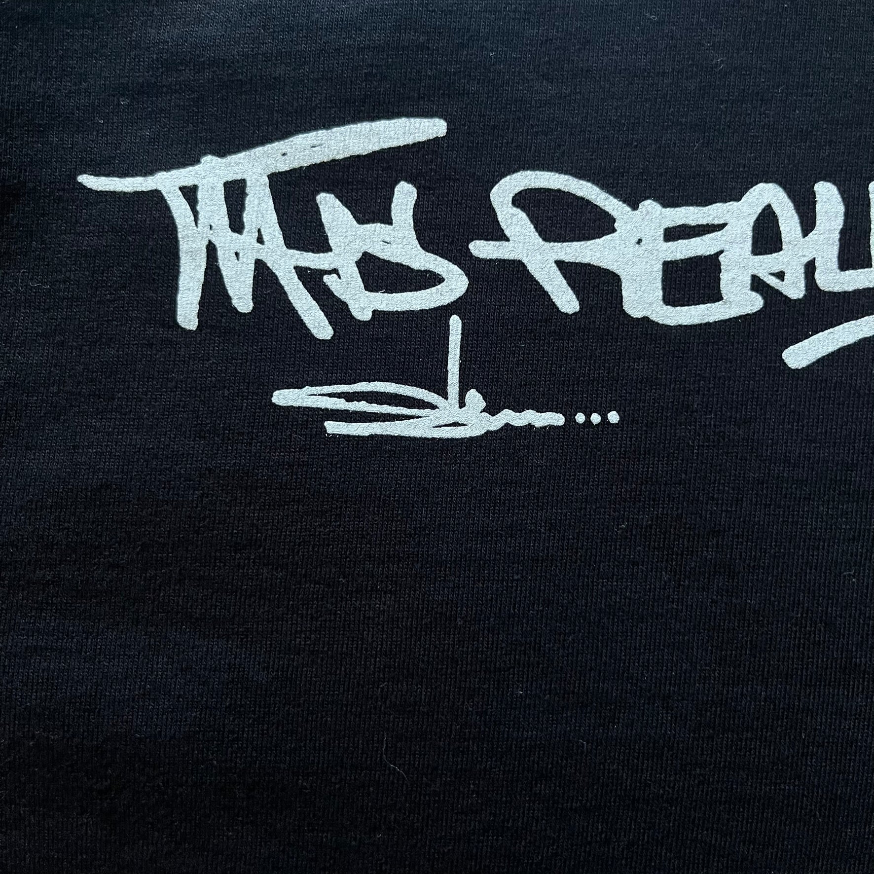 Black Batpreme tee designed by Slawn with Supreme Box Logo and his iconic Batman graphic on the front. Printed neck tag with signature and back shows handwritten-style text saying “This really isn’t real Supreme” with Slawn signature and the Supreme bogo. A rare, art-driven streetwear essential.