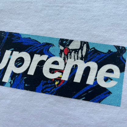 White Slawn Batpreme tee featuring a Batman-inspired graphic with iconic twist by Slawn and Supreme text overlay. Printed neck tag shows Slawn’s signature, while the back reads “This really isn’t real Supreme” in hand-drawn style with signature and logo. A striking, collectible streetwear piece.