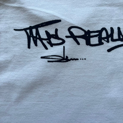 White Slawn Batpreme tee featuring a Batman-inspired graphic with iconic twist by Slawn and Supreme text overlay. Printed neck tag shows Slawn’s signature, while the back reads “This really isn’t real Supreme” in hand-drawn style with signature and logo. A striking, collectible streetwear piece.