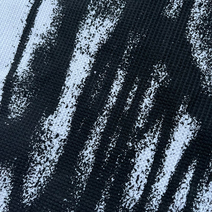 White waffle-knit / thermal long sleeve top made from textured fabric. Features a large black back print of Slawn’s dripping graffiti face, printed with fine line detail and layered ink effects. The front is finished with a small Slawn signature print near the hem, along with a neck tag bearing the artist’s signature.