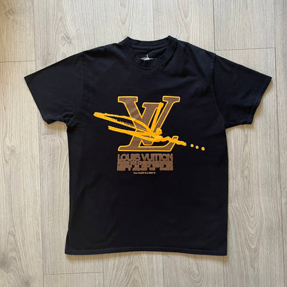Black t-shirt with gold and brown graphic design on a wooden floor