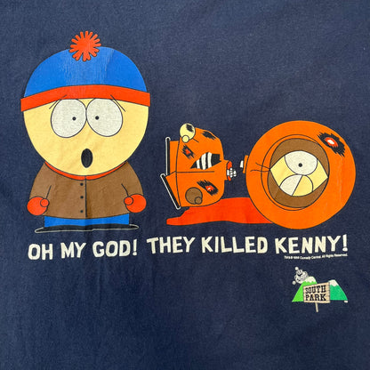South Park 1998 “They Killed Kenny” Navy Tee features a a front graphic of Stan standing with a surprised expression next to a fallen Kenny. Below the characters is white “Oh My God! They Killed Kenny!” text, with a small South Park logo and 1998 licensing detail printed underneath on the right side. Made from cotton.