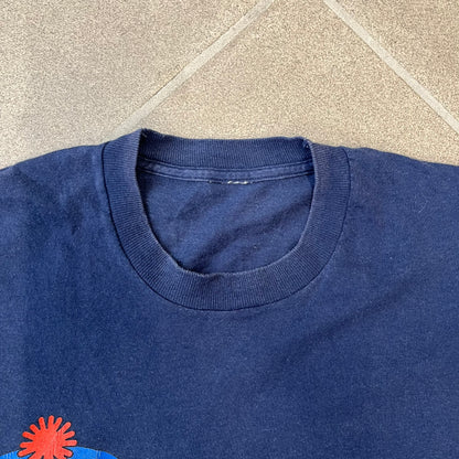 South Park 1998 “They Killed Kenny” Navy Tee features a a front graphic of Stan standing with a surprised expression next to a fallen Kenny. Below the characters is white “Oh My God! They Killed Kenny!” text, with a small South Park logo and 1998 licensing detail printed underneath on the right side. Made from cotton.