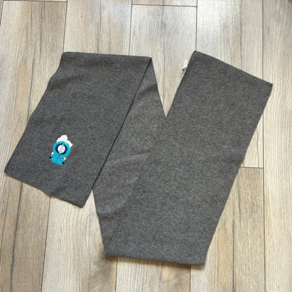 South Park 2000 Frozen Kenny Scarf is a grey scarf featuring a graphic of Kenny rendered in a frozen state in blue tones. The character is shown with ice and snow effects covering the head area. The scarf includes a South Park Comedy Central tag and 2000 licensing details.
