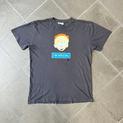 South Park 2008 Timmy “I’m Special” Tee features a grey T-shirt with a front graphic of Timmy’s face above a blue bar with white “I’m Special” text. Small 2008 licensing and Comedy Central details are printed underneath. The back features a blue and white wheelchair-accessibility sign graphic. Includes a licensed South Park neck tag.
