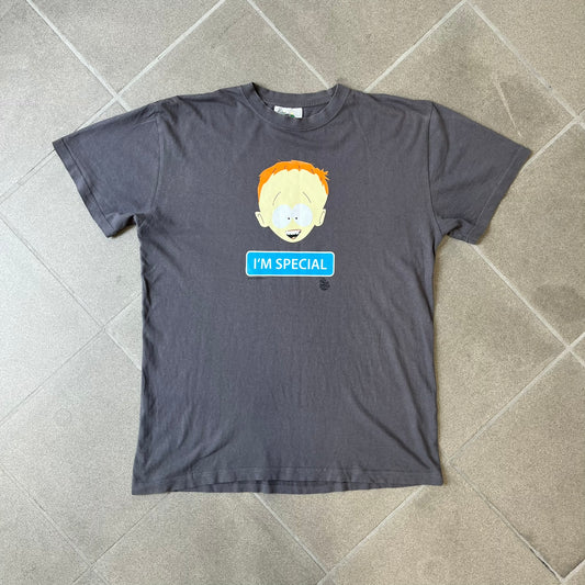 South Park 2008 Timmy “I’m Special” Tee features a grey T-shirt with a front graphic of Timmy’s face above a blue bar with white “I’m Special” text. Small 2008 licensing and Comedy Central details are printed underneath. The back features a blue and white wheelchair-accessibility sign graphic. Includes a licensed South Park neck tag.
