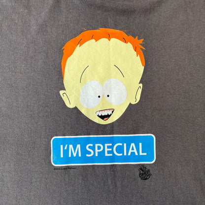 South Park 2008 Timmy “I’m Special” Tee features a grey T-shirt with a front graphic of Timmy’s face above a blue bar with white “I’m Special” text. Small 2008 licensing and Comedy Central details are printed underneath. The back features a blue and white wheelchair-accessibility sign graphic. Includes a licensed South Park neck tag.
