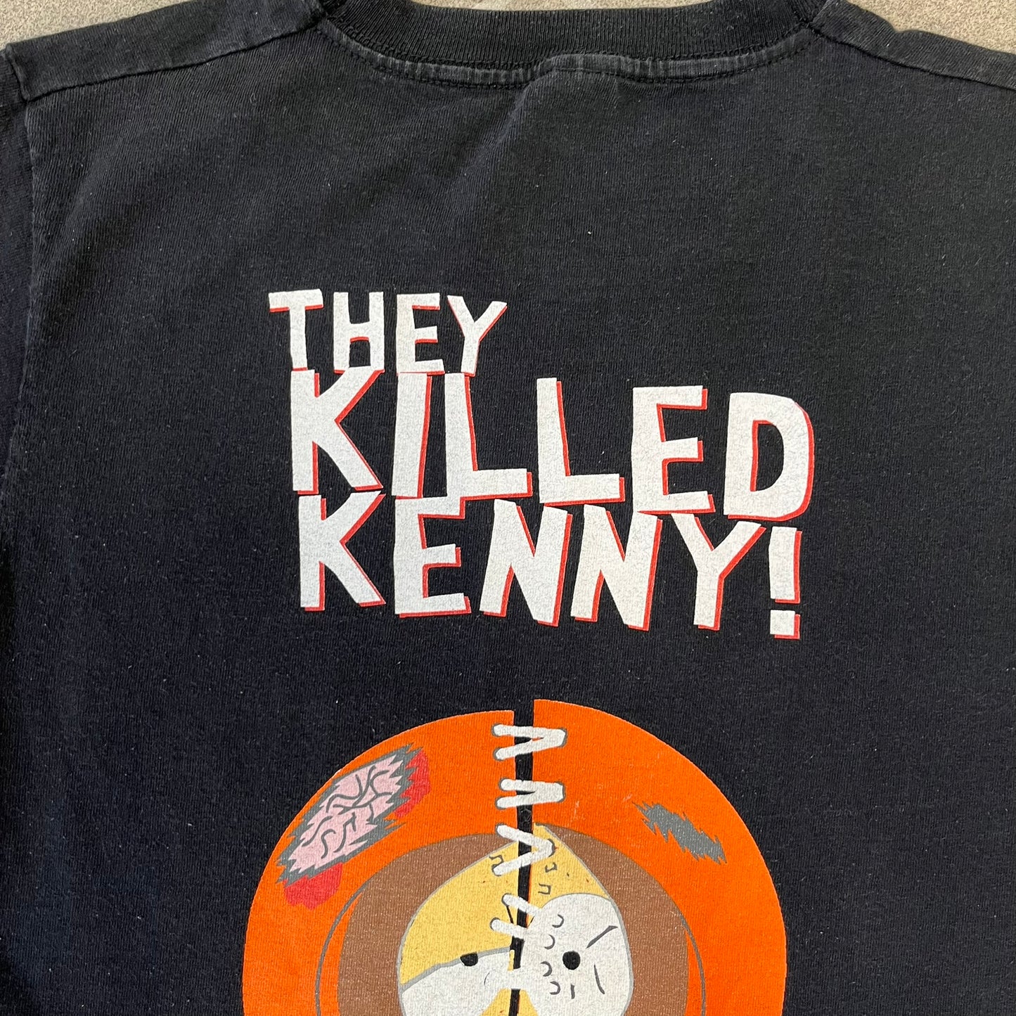 South Park 2009 “Oh My God, They Killed Kenny!” Tee is a black T-shirt made on a Fruit of the Loom blank. The front features a large graphic of Kyle with “Oh My God,” printed above and 2009 South Park licensing below. The back shows a stitched version of Kenny with “They Killed Kenny!” printed above the graphic.
