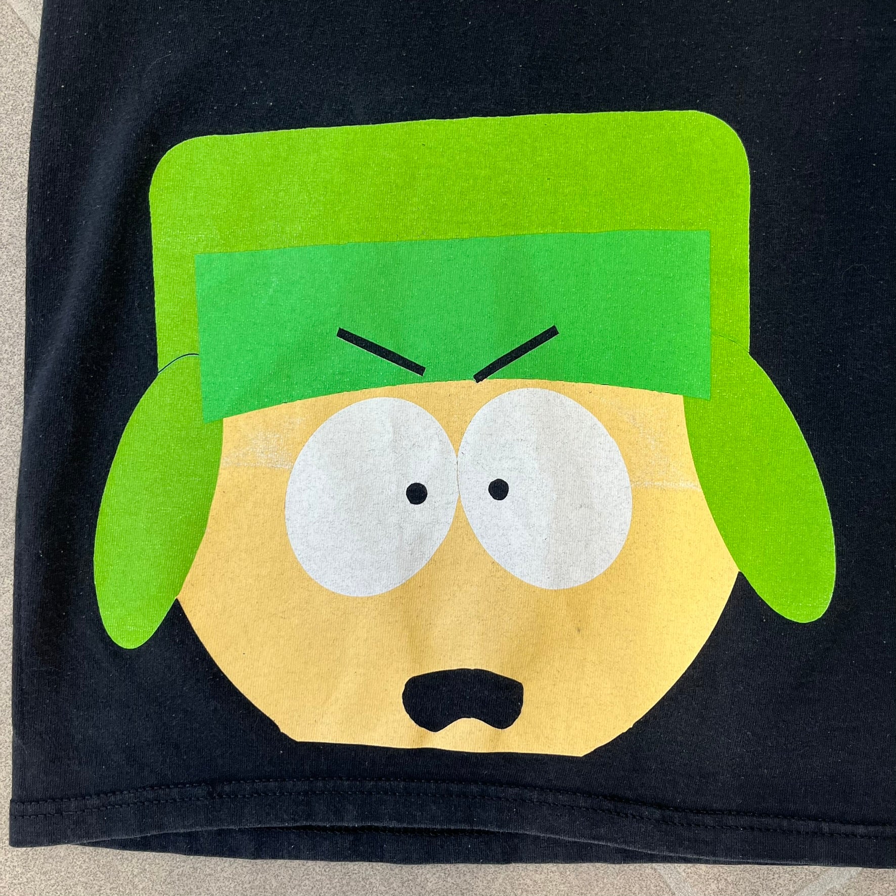 South Park 2009 “Oh My God, They Killed Kenny!” Tee is a black T-shirt made on a Fruit of the Loom blank. The front features a large graphic of Kyle with “Oh My God,” printed above and 2009 South Park licensing below. The back shows a stitched version of Kenny with “They Killed Kenny!” printed above the graphic.
