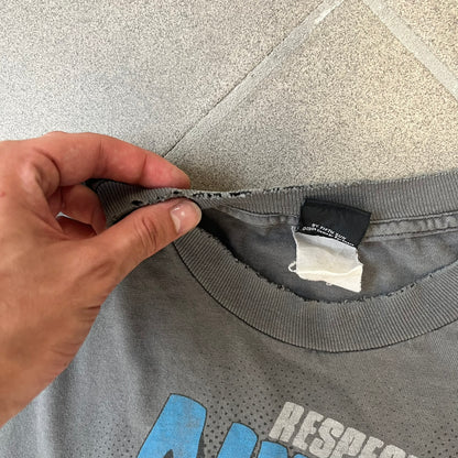 South Park 2009 “Respect My Authority” Gray Tee features a grey T-shirt with a front graphic of Cartman wearing a police uniform and running across a dotted cartoon-style background. Above the graphic is white and blue “Respect My Authority” text. The shirt has a South Park 2009 licensed neck tag and a heavily worn, distressed condition.
