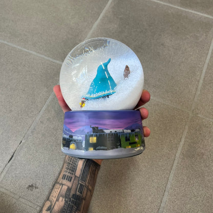 Exclusive South Park Snow Day Grand Wizard Cartman Snowglobe. Showcases Cartman in full wizard attire within a globe packed with dense snow for a humorous effect, making Cartman almost disappear beneath the flakes. Officially licensed piece with 2024 Comedy Partners text on the base.