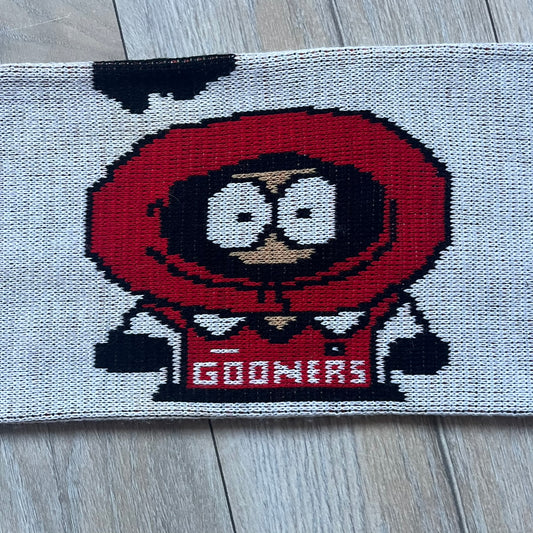 Vintage football scarf in white and black with red fringe / tassels, featuring South Park characters including Kenny, Cartman, and Kyle dressed in Arsenal kits with “Gooners” text. The character graphics appear on both sides of the scarf, with consistent coloring in white and red. Soft knit construction with a classic football scarf shape and finish.