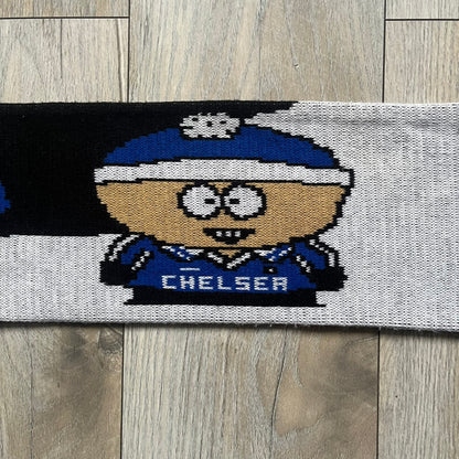 Vintage football scarf in white and black with blue fringe / tassels, featuring South Park characters including Kenny, Cartman, and Kyle dressed in Chelsea kits. The character graphics appear on both sides of the scarf, with consistent coloring in blue. Soft knit construction with a classic football scarf shape and finish.