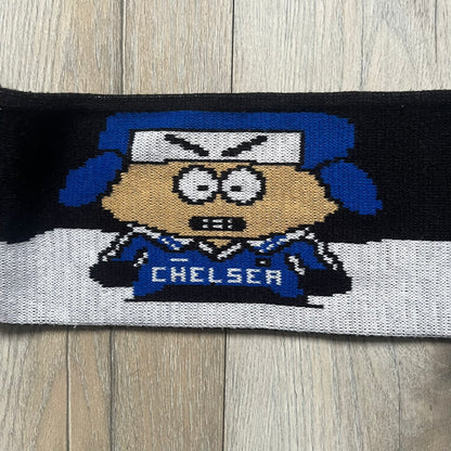 Vintage football scarf in white and black with blue fringe / tassels, featuring South Park characters including Kenny, Cartman, and Kyle dressed in Chelsea kits. The character graphics appear on both sides of the scarf, with consistent coloring in blue. Soft knit construction with a classic football scarf shape and finish.