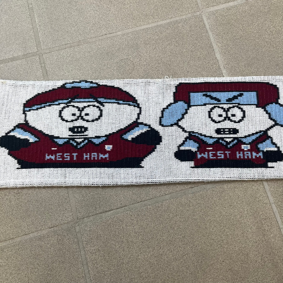 Vintage South Park West Ham 1990's Football Scarf in white and burgundy with fringe / tassels, featuring South Park characters including Kenny, Cartman, Kyle and Stan dressed in West Ham kits. The character graphics appear on both sides of the scarf, with consistent coloring in Burgundy and light blue.