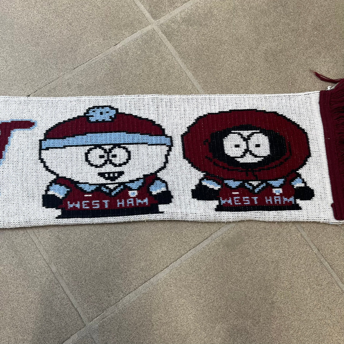 Vintage South Park West Ham 1990's Football Scarf in white and burgundy with fringe / tassels, featuring South Park characters including Kenny, Cartman, Kyle and Stan dressed in West Ham kits. The character graphics appear on both sides of the scarf, with consistent coloring in Burgundy and light blue.
