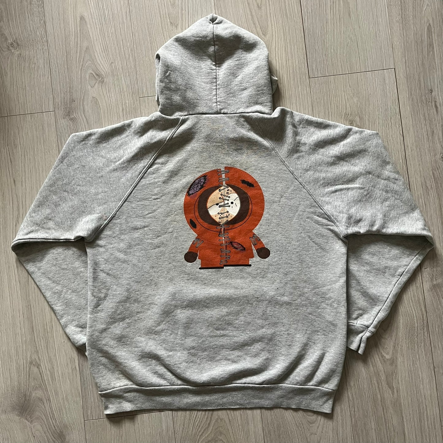 South Park “Stitched Up Kenny” Hoodie from 1998 in Gray, made on a Screen Stars blank. Features a small South Park logo on the chest and a large stitched-up Kenny graphic on the back. Vintage licensed piece from the show’s early era.