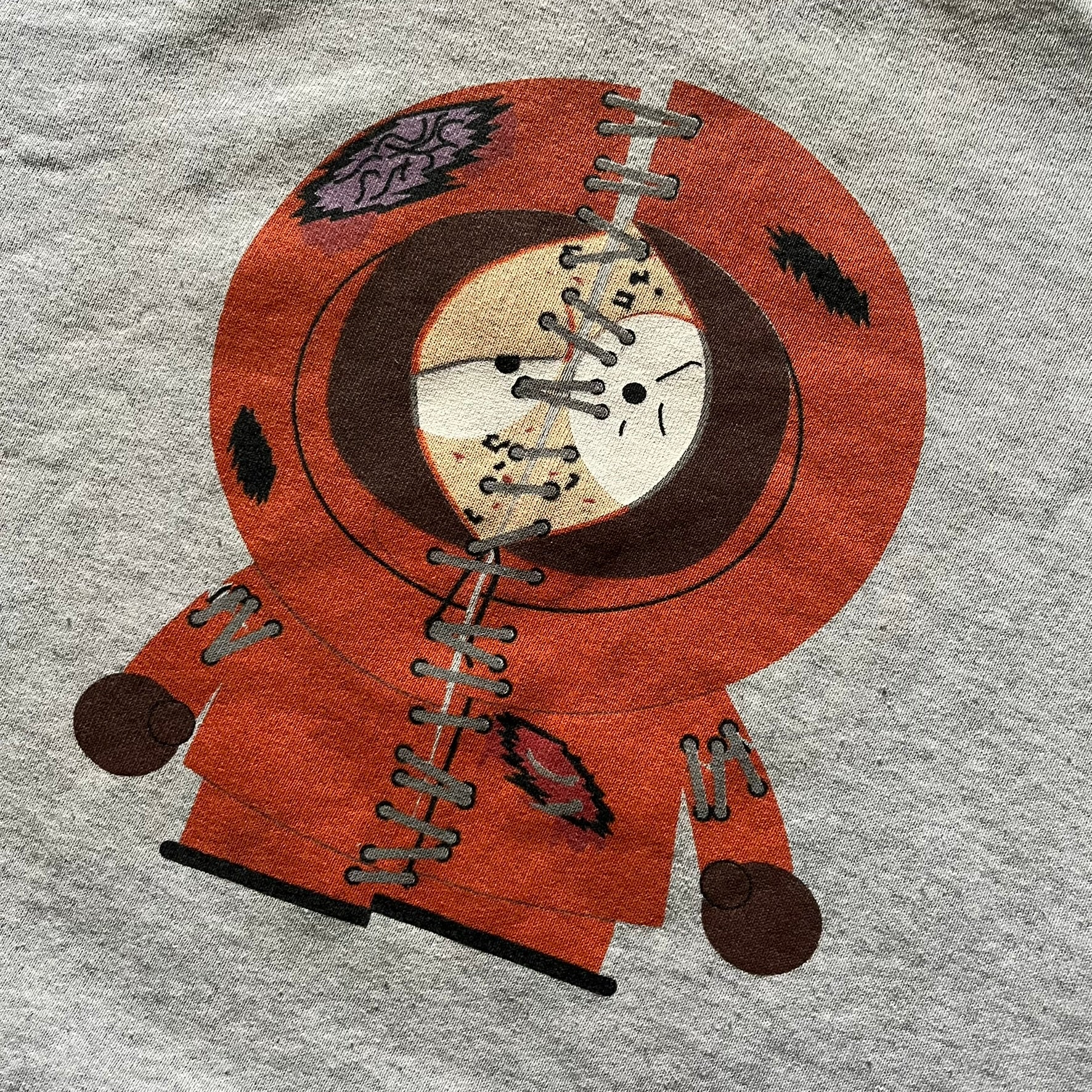 South Park “Stitched Up Kenny” Hoodie from 1998 in Gray, made on a Screen Stars blank. Features a small South Park logo on the chest and a large stitched-up Kenny graphic on the back. Vintage licensed piece from the show’s early era.