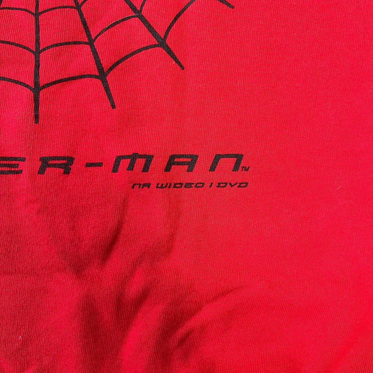 Spider-Man 2002 Hoop Cola Promo Red Crewneck is a rare Poland-exclusive crewneck made for the cross-promotional campaign between Hoop Cola and Warner Bros for the Spider-Man (2002) film. It was never sold in stores and was given out only as a prize in the SMS code contest. The cotton crewneck features web with eyes graphic in the middle, Spider-Man logo under and a Hoop Cola logo above.