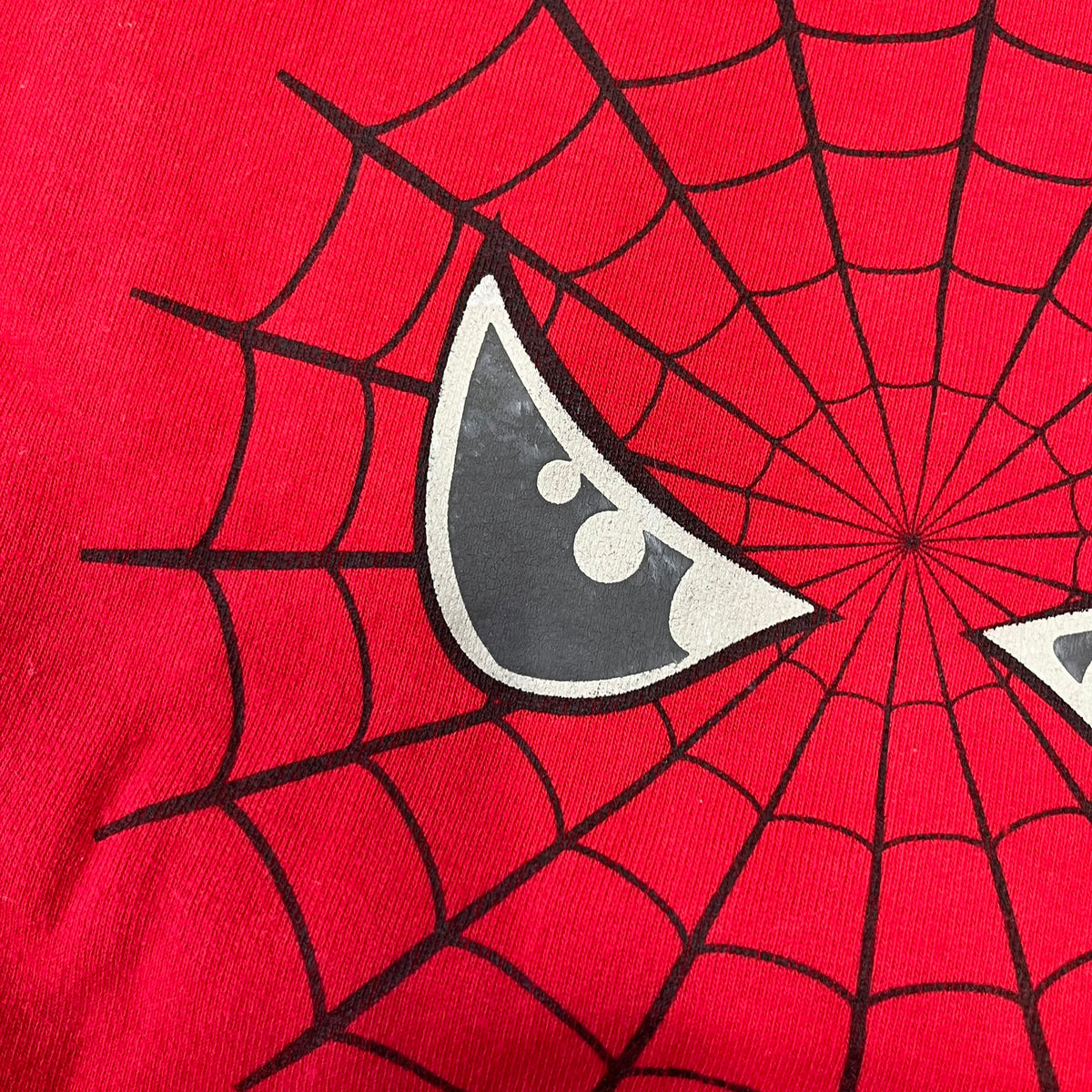 Spider-Man 2002 Hoop Cola Promo Red Crewneck is a rare Poland-exclusive crewneck made for the cross-promotional campaign between Hoop Cola and Warner Bros for the Spider-Man (2002) film. It was never sold in stores and was given out only as a prize in the SMS code contest. The cotton crewneck features web with eyes graphic in the middle, Spider-Man logo under and a Hoop Cola logo above.