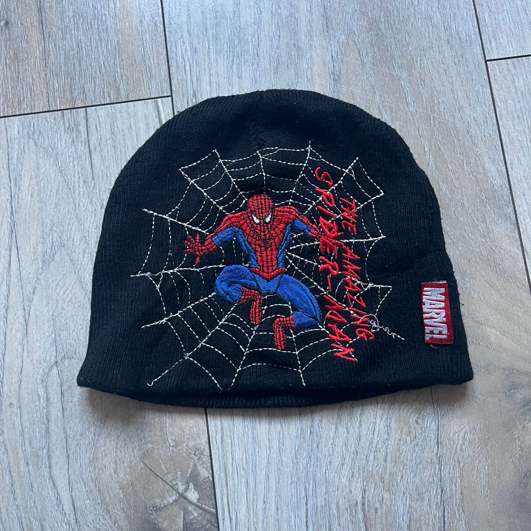 This vintage 2006 Spider-Man beanie by Contrast comes in black and features an embroidered design of Spider-Man on a web with “The Amazing Spider-Man” text. Officially licensed, it’s a nostalgic collectible that captures the mid-2000s comic and pop culture era.