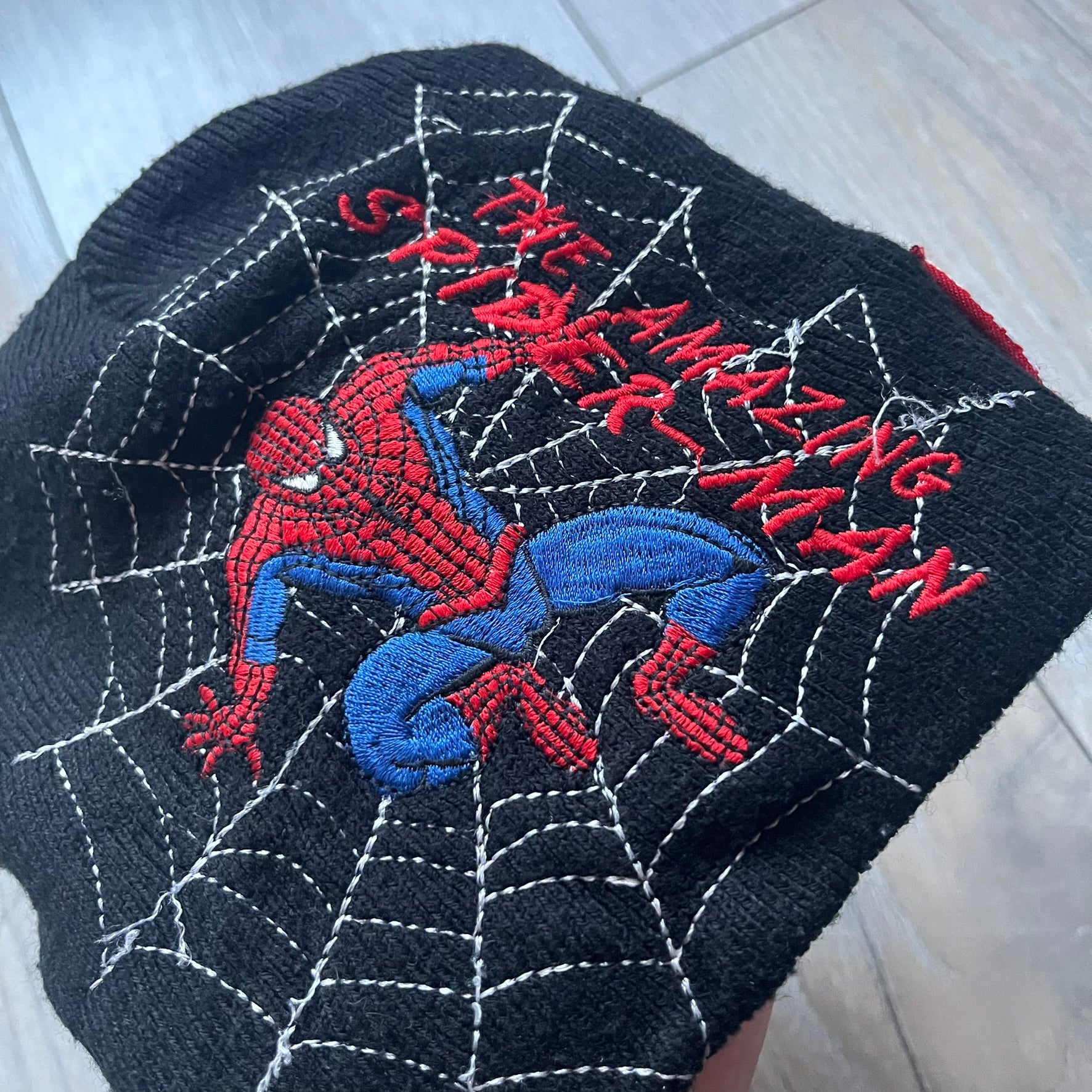 This vintage 2006 Spider-Man beanie by Contrast comes in black and features an embroidered design of Spider-Man on a web with “The Amazing Spider-Man” text. Officially licensed, it’s a nostalgic collectible that captures the mid-2000s comic and pop culture era.
