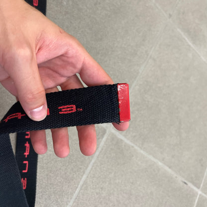 Spider-Man 3 2007 Black Belt is a black adjustable belt featuring repeated horizontal red Spider-Man 3 logo graphics across the strap. The belt has a red metal buckle with a Spider-Man graphic on the front showing him swinging. It includes a metal belt tip finish and a regulated sizing system for adjustment.

