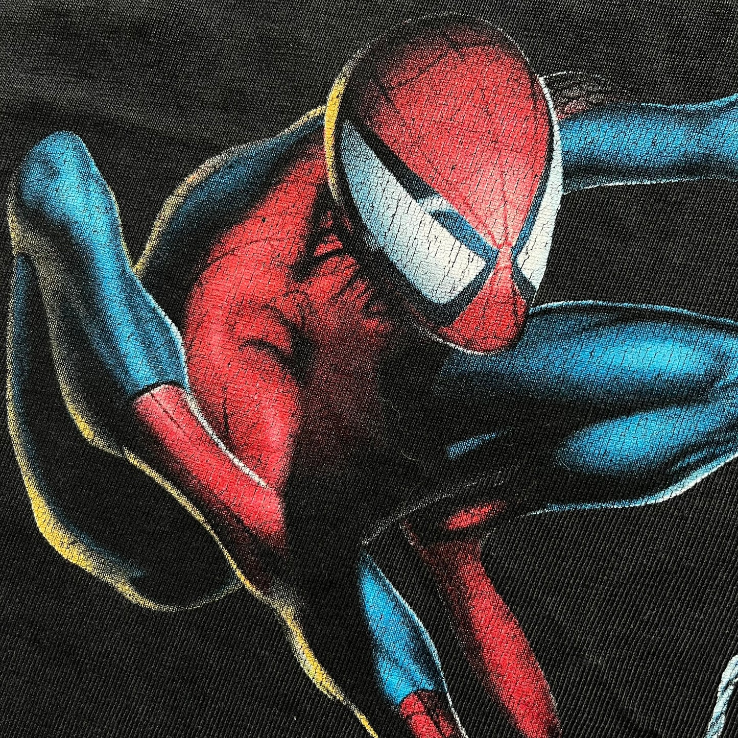 Spider-Man Swinging 2003 Washed Longsleeve is a washed black and dark gray cotton long-sleeve shirt made on a Hanes Beefy-T blank. The front features a large detailed comic-style Spider-Man graphic in red and blue, showing the character swinging in motion. Made from 100% cotton with a faded vintage finish.
