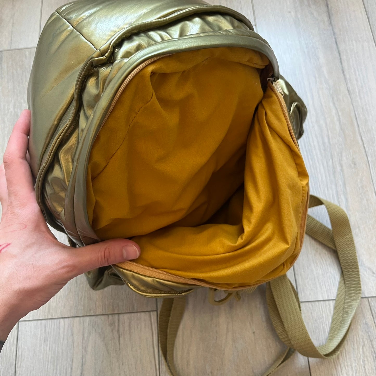 Star Wars 1990s C-3PO Head Backpack is a novelty backpack shaped like the head of C-3PO. It features a metallic gold finish with detailed sculpted paneling and plastic lens-style eyes for a robotic look. The bag includes a 1990s Star Wars red licensed tag and a single main compartment.