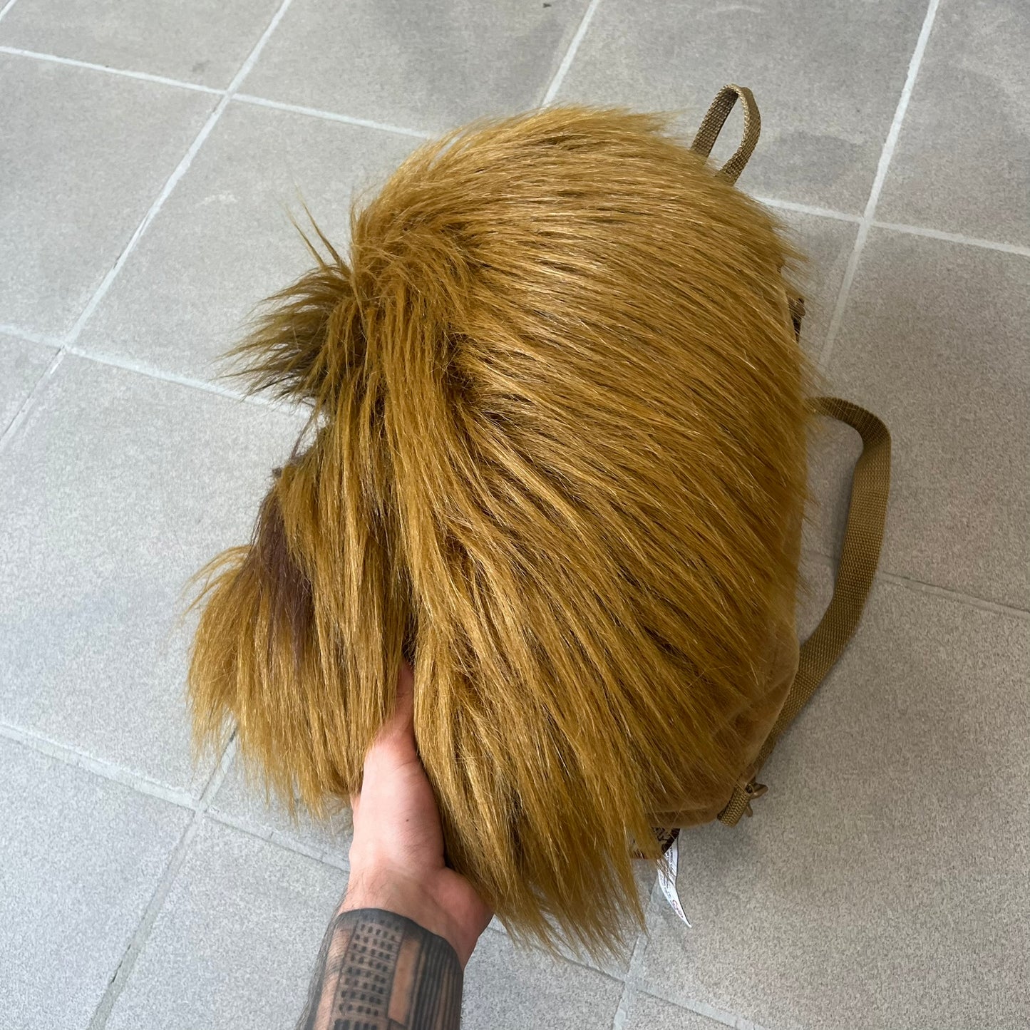 Star Wars 1990s Chewbacca Head Backpack is a novelty bag designed in the shape of Chewbacca’s head. The exterior features a furry construction with plastic eyes and a leather-like nose and mouth. It includes an adjustable shoulder straps, a single main compartment and a red Star Wars licensed tag.