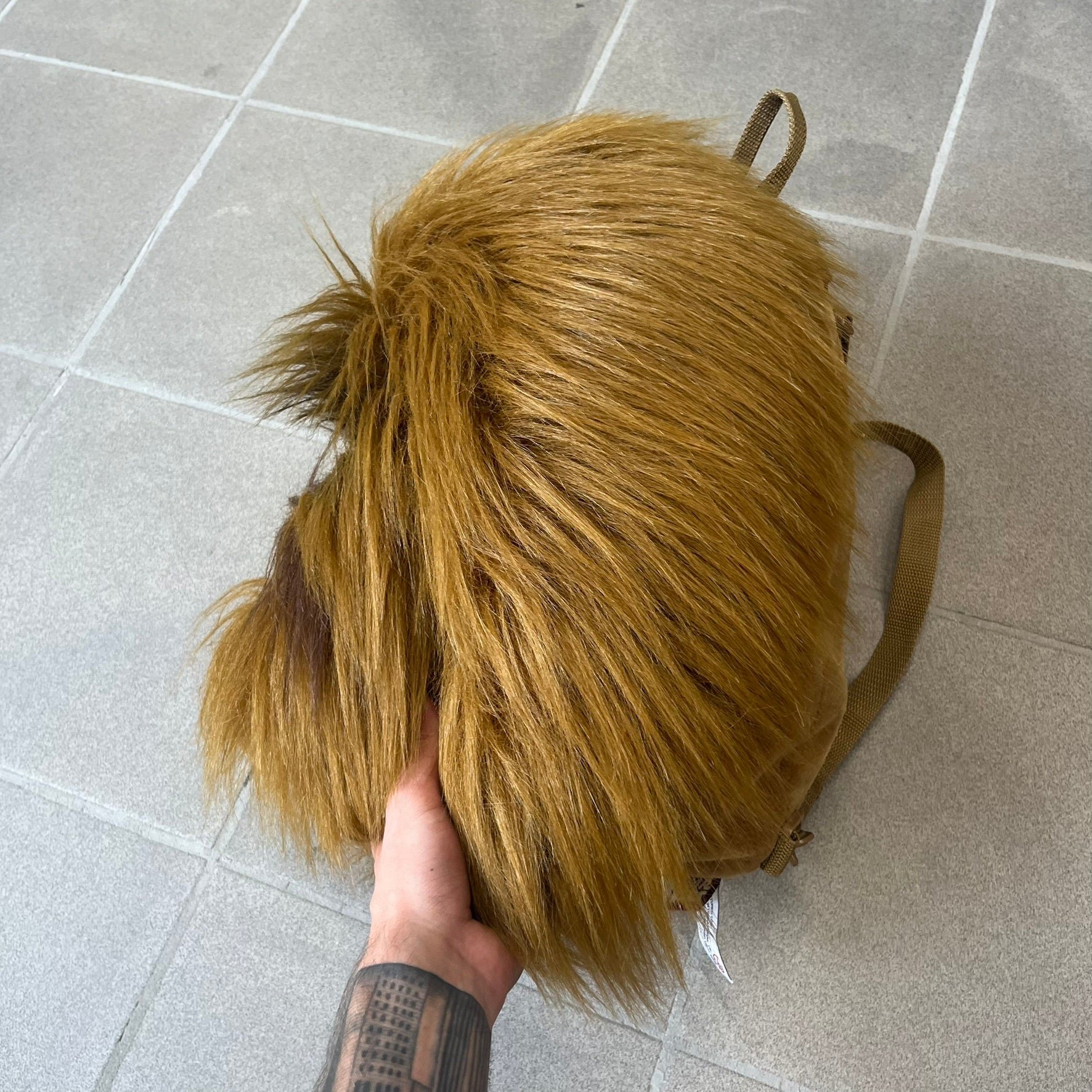 Star Wars 1990s Chewbacca Head Backpack is a novelty bag designed in the shape of Chewbacca’s head. The exterior features a furry construction with plastic eyes and a leather-like nose and mouth. It includes an adjustable shoulder straps, a single main compartment and a red Star Wars licensed tag.