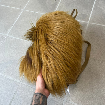 Star Wars 1990s Chewbacca Head Backpack is a novelty bag designed in the shape of Chewbacca’s head. The exterior features a furry construction with plastic eyes and a leather-like nose and mouth. It includes an adjustable shoulder straps, a single main compartment and a red Star Wars licensed tag.