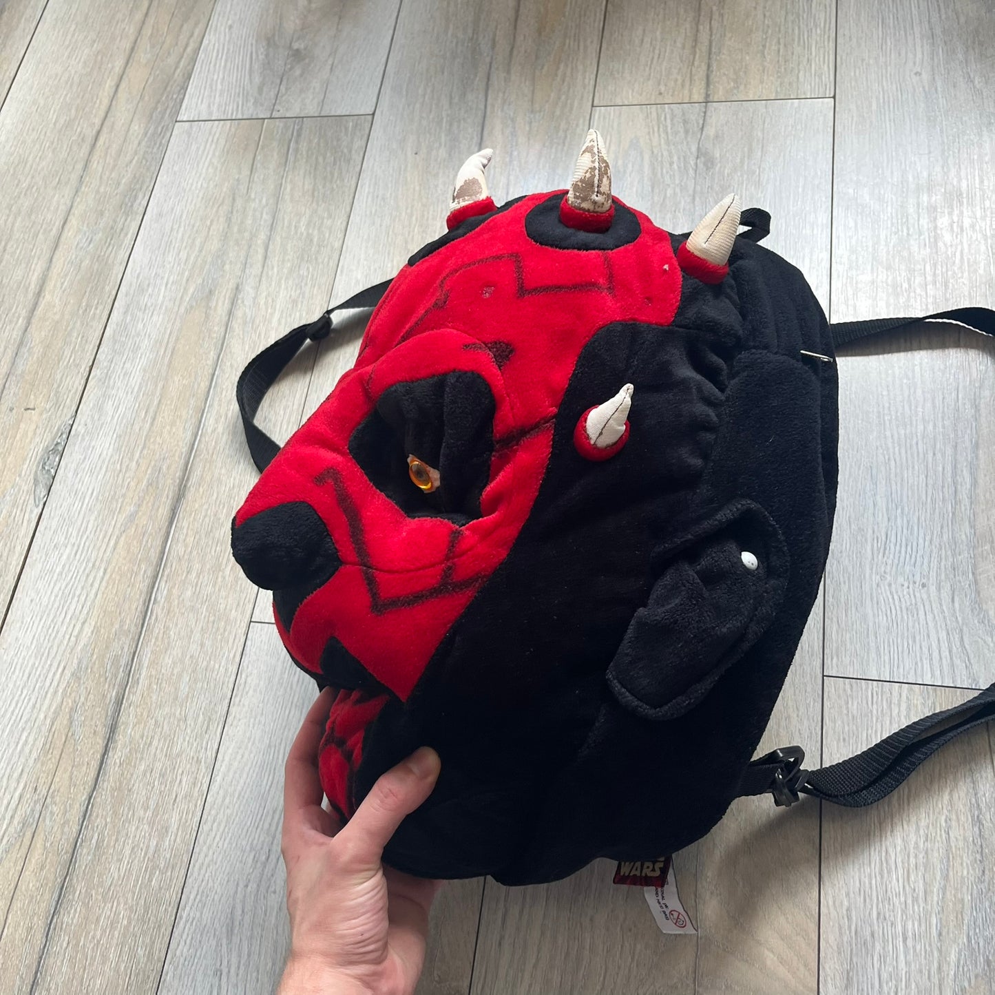 Star Wars 90's Darth Maul Head Backpack is a plush backpack shaped like Darth Maul’s head with striking red-and-black detailing and realistic plastic eyes. Features a small zip compartment on the back and adjustable straps, perfect as a collectible or standout accessory.