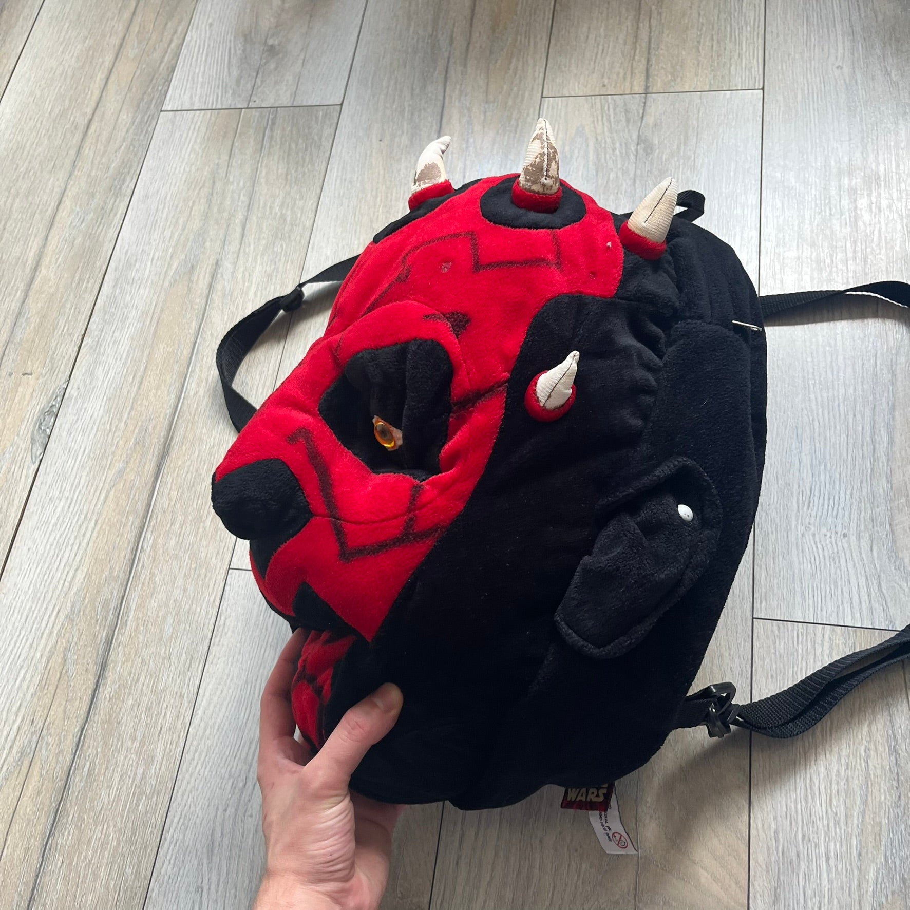 Star Wars 90's Darth Maul Head Backpack is a plush backpack shaped like Darth Maul’s head with striking red-and-black detailing and realistic plastic eyes. Features a small zip compartment on the back and adjustable straps, perfect as a collectible or standout accessory.