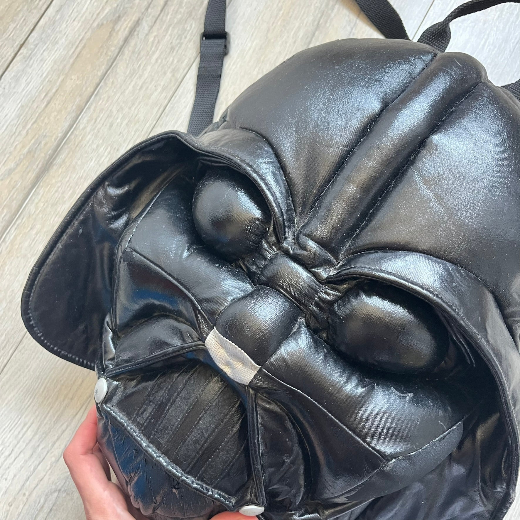 Star Wars 1990s Darth Vader Head Backpack is a vintage backpack shaped like Darth Vader’s helmet. It is finished in shiny black with molded plastic details recreating the character’s mask and helmet. The bag has one main compartment and includes a red Star Wars licensed tag from the 1990s.
