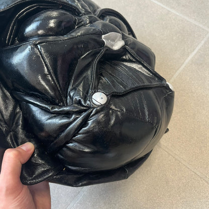 Star Wars 1990s Darth Vader Head Backpack is a vintage backpack shaped like Darth Vader’s helmet. It is finished in shiny black with molded plastic details recreating the character’s mask and helmet. The bag has one main compartment and includes a red Star Wars licensed tag from the 1990s.