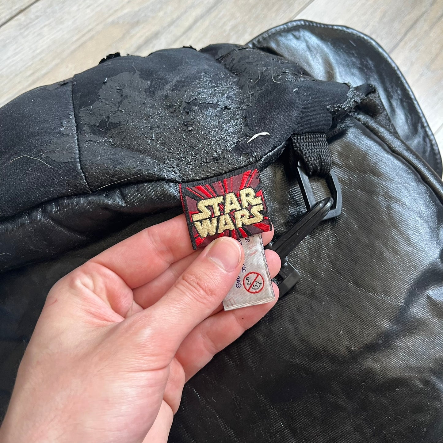 Star Wars 1990s Darth Vader Head Backpack is a vintage backpack shaped like Darth Vader’s helmet. It is finished in shiny black with molded plastic details recreating the character’s mask and helmet. The bag has one main compartment and includes a red Star Wars licensed tag from the 1990s.

