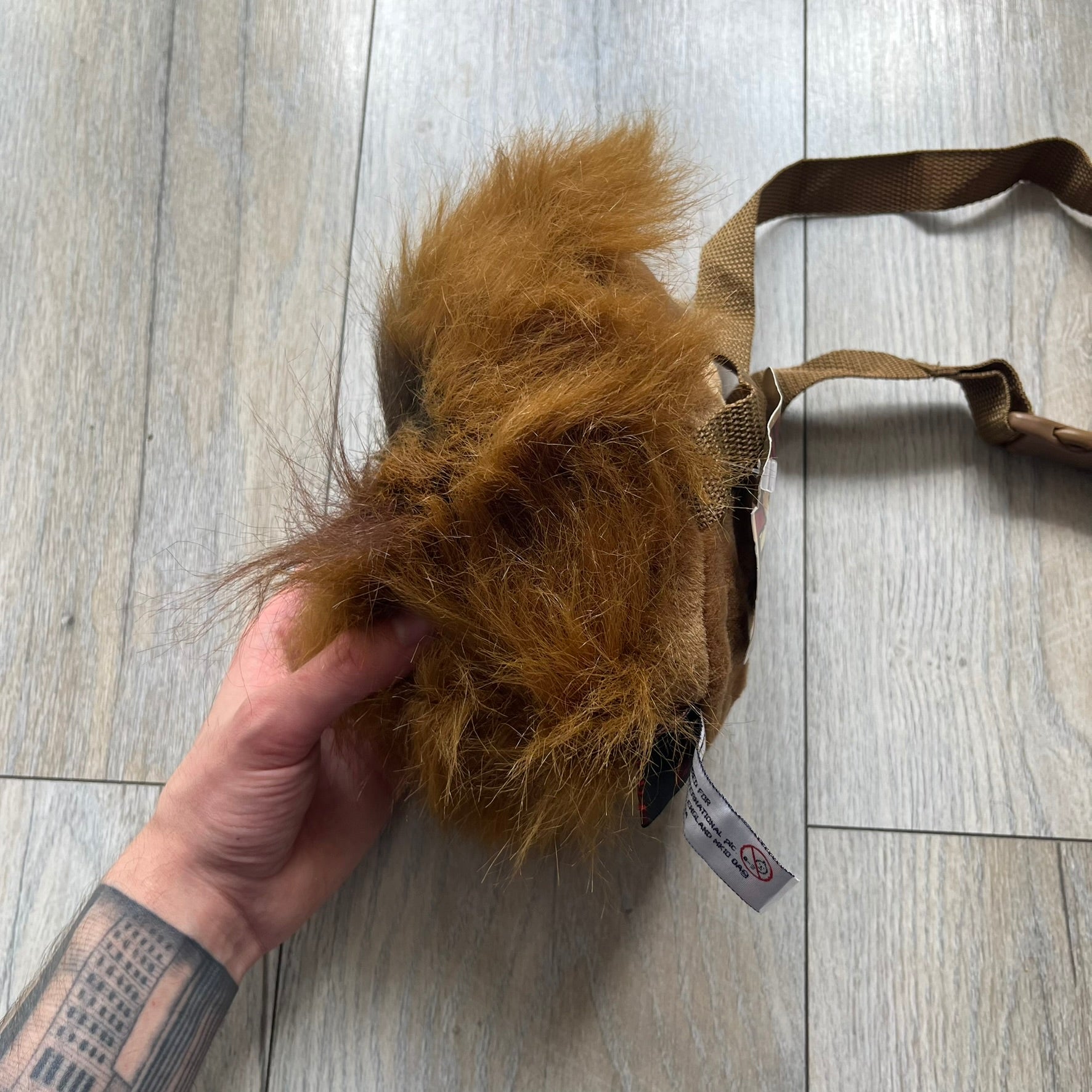 Star Wars 1990s Chewbacca Head Shoulder Bag is a novelty shoulder bag designed in the shape of Chewbacca’s head. The exterior features a furry construction with plastic eyes and a leather-like nose and mouth. It includes an adjustable shoulder strap, a single main compartment, a red Star Wars licensed tag, and the original paper tag.