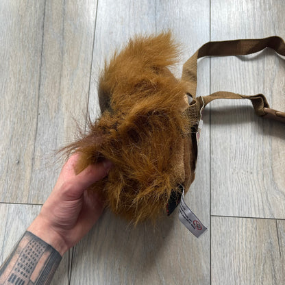 Star Wars 1990s Chewbacca Head Shoulder Bag is a novelty shoulder bag designed in the shape of Chewbacca’s head. The exterior features a furry construction with plastic eyes and a leather-like nose and mouth. It includes an adjustable shoulder strap, a single main compartment, a red Star Wars licensed tag, and the original paper tag.